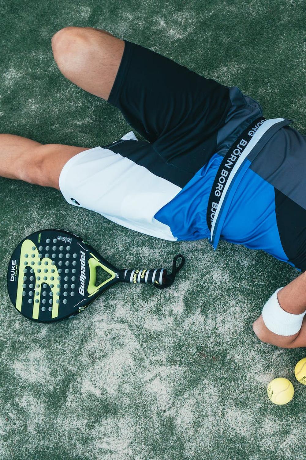 man_lying_beside_on_green_tennis_balls