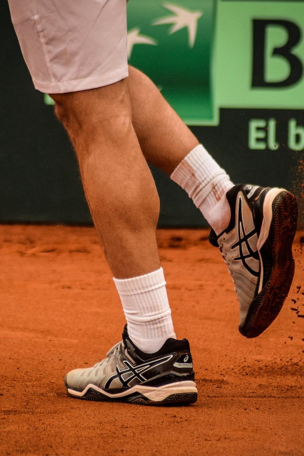 man_wearing_black_and_white_asics_athletic_shoes_h