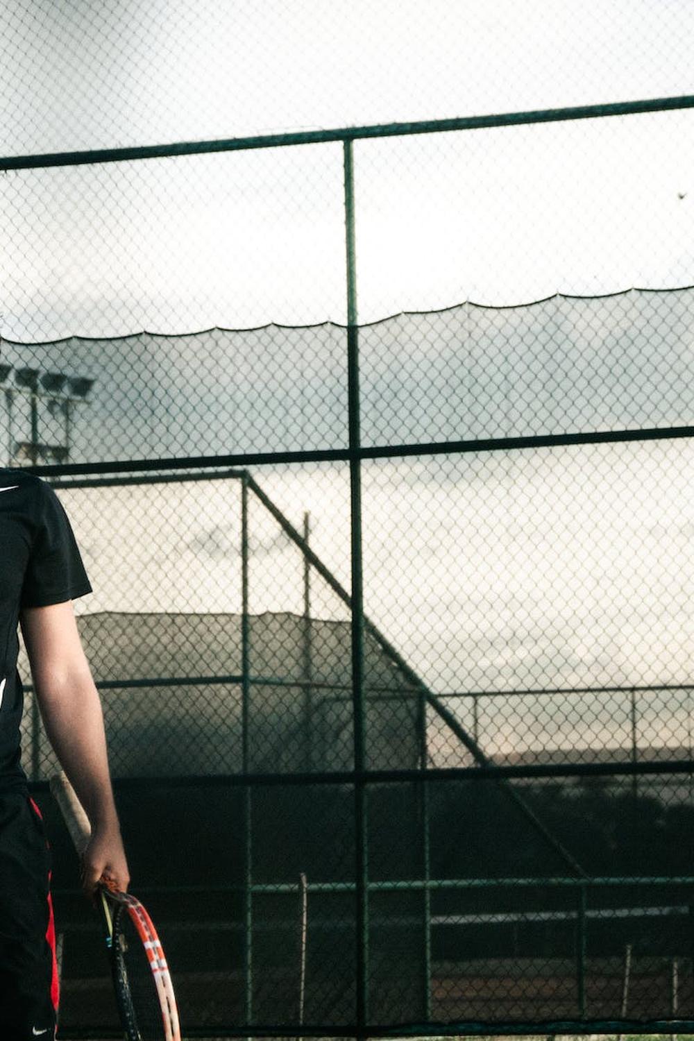 man_wearing_black_nike_dri_fit_shirt_holding_a_ten