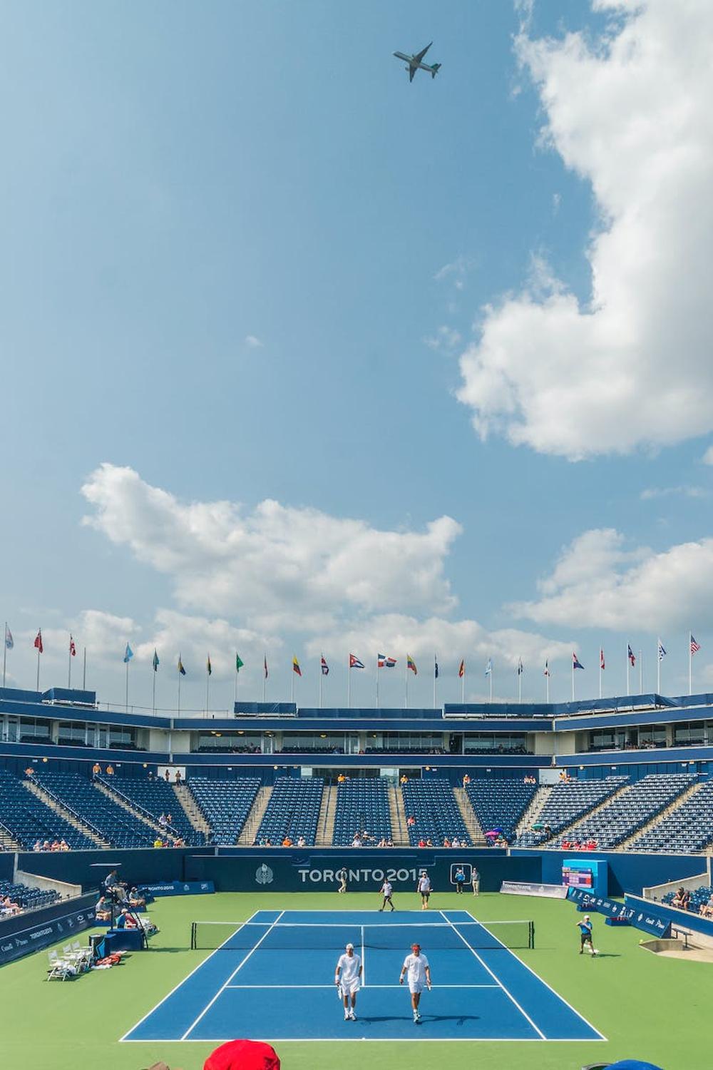 people_standing_on_blue_and_green_tennis_court